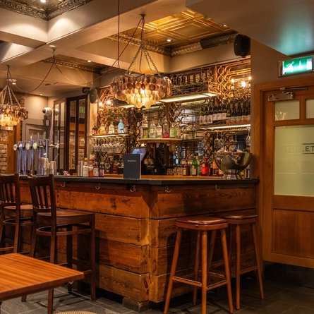 The interior bar with bar stools and seating area at the Ubiquitous Chip.