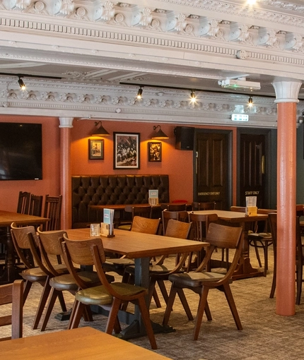 The interior restaurant seating area with TVs, at Coopers in Glasgow.