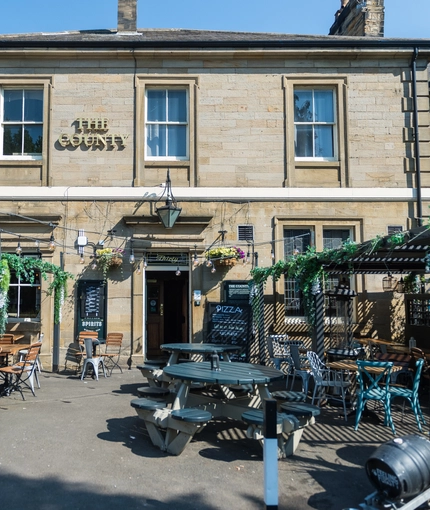 External view of a pub entrance and outdoor seating area