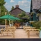 The exterior patio beer garden seating area with wooden benches, planters and hanging baskets at The Church View Inn.