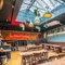 The interior of one of the function room with glass ceiling, hanging baskets, advertising chalkboard signage and a food cabinet counter at The Vine.