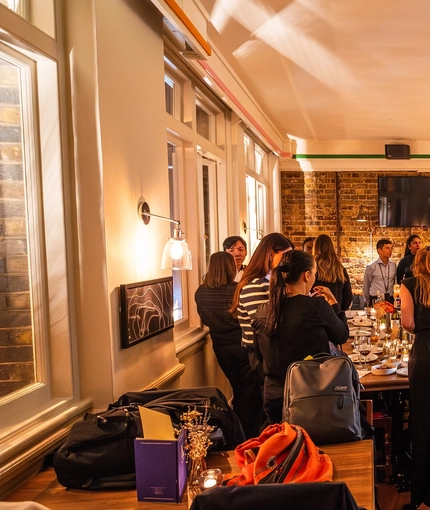 An image of customers stood within the interior restaurant seating area with the bar in the background enjoying drinks at The Kings Stores.