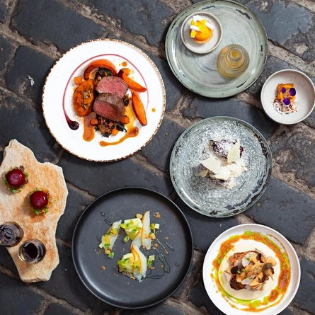 An interior shot of a variety of food plated up at the Ubiquitous Chip in Glasgow.