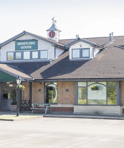 Exterior facade of a pub with a seating area,
