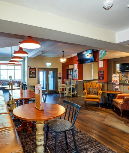 Interior dining area of a pub with a TV.