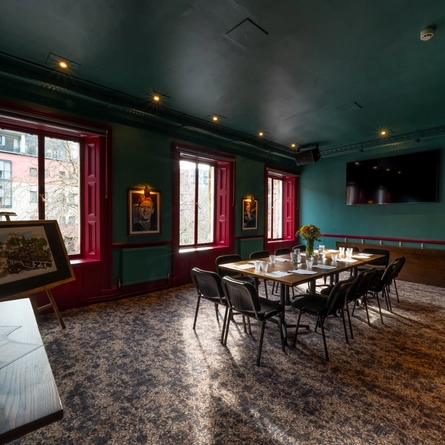 A large function/meeting room at The Beehive Inn, with a boardroom table, and a TV on the wall.