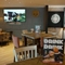 The interior restaurant seating area of The Steam Turbine, with a TV on the wall, and a dartboard.