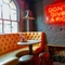 an interior seating area with neon sign