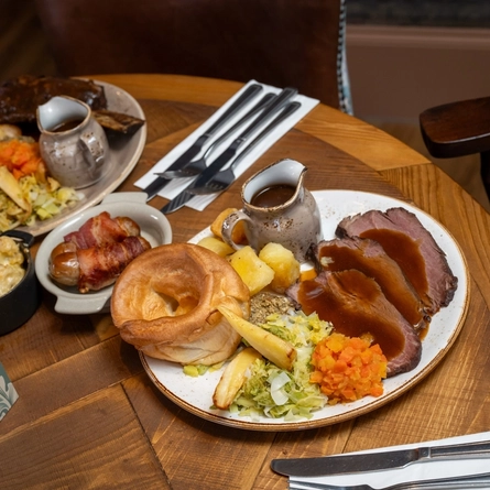 Image of a roast dinner plated on the table with the cutlery placed at the side of the plate.