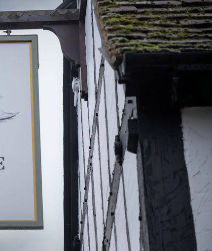 A close up view of the pub sign hanging on the exterior wall of Ye Olde Swan.