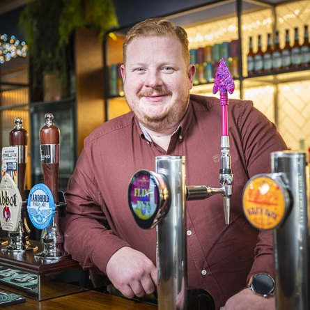 A man standing behind a bar.