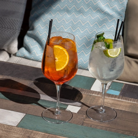 An Aperol and a Mojito Spritz cocktail on a table.