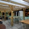 The undercover exterior beer garden seating area at The White Hart in Frimley, with a TV on the wall.