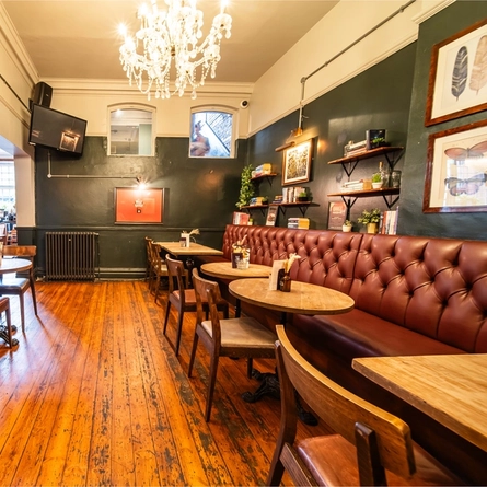The interior restaurant seating area with exposed brickwork feature wall and TV within one of the function rooms at The Vine.