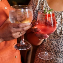 An interior close up image of a glass of gin and a cocktail style drink during the Q3 Happy Hour Event.