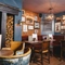An interior restaurant seating area at Ye Olde Swan, with an upholstered corner seat, and framed artwork on the walls.