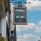A close up image showing the exterior venue hanging signage featuring an old illustration of the venue at The Watergates Bar.