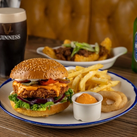 A plated Spicy Franks Mayo Chicken Burger on an indoor wooden table.