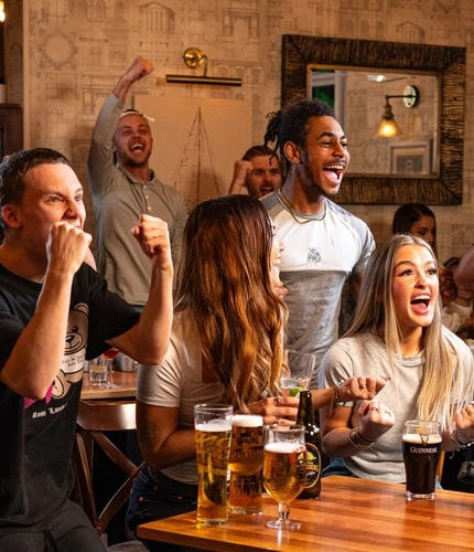 A group of friends watching and cheering at the Football.