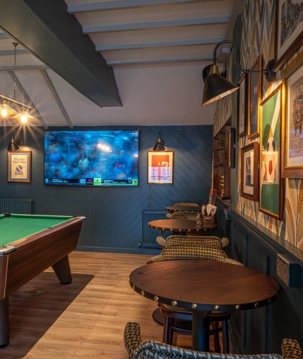 An image of the seating and games area with TV and pool table at The Old Red Lion.