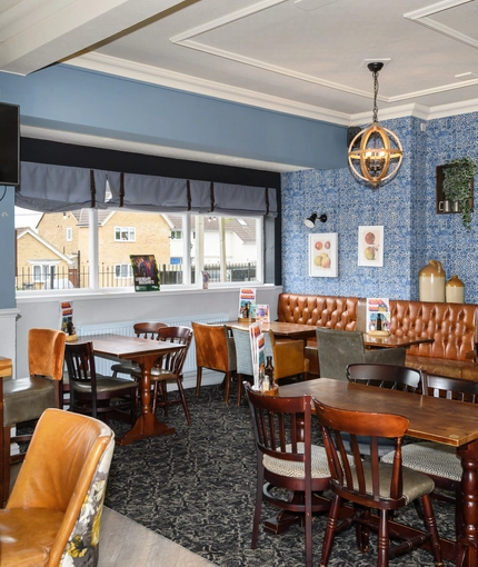 Interior dining area of a pub with a TV.