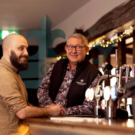 2 staff members stood at the bar at a Nest venue.