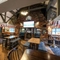 Interior dining area of a pub with a fireplace, a gambling machine and a TV.