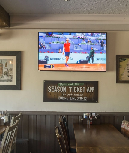Interior dining area of a pub with a TV.