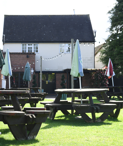 Exterior beer garden of a pub with a seating area.