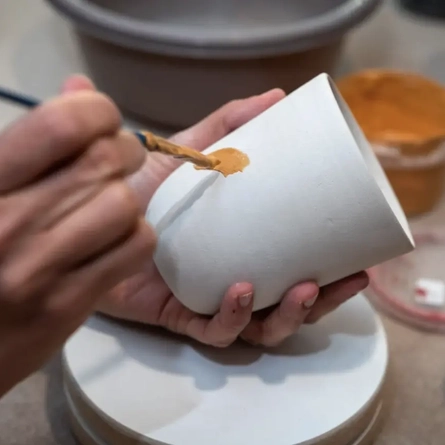 An image of someone painting a pot advertising a Pottery Painting What's On event at The Foundry Bell.