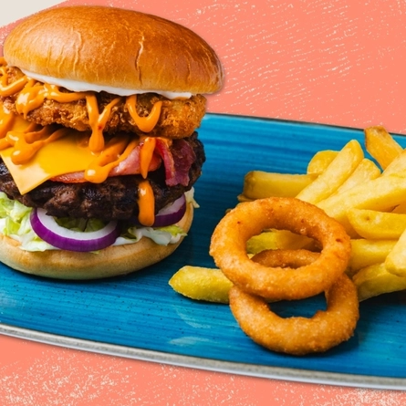 A main signature burger served to advertise burgers on offer at Flaming Grill venues on a textured green background.