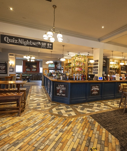 Interior dining area of a pub with a bar.