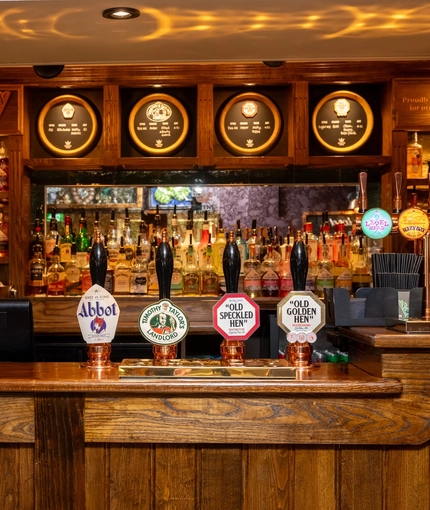 The interior bar focusing on a pump with several pump clips including Abbot, Old Speckled Hen, Old Golden Hen and Timothy Taylors Landlord all served at the Apple Tree.