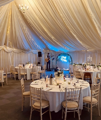 A marquee, decorated for a wedding.