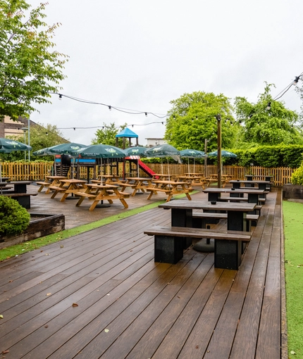 Exterior beer garden and a play area of a pub with a seating area.