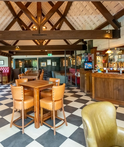 Interior dining area of a pub with a bar and a TV.