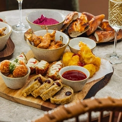 A variety of grazing board small plate sharer dishes sat on a table within the exterior beer garden seating area at a Crafted venue.