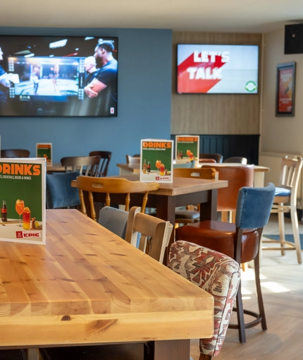 The interior restaurant and seating area with TV at the Woodlands Edge.