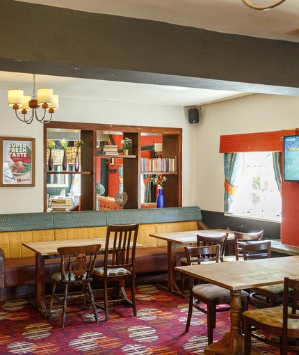 Interior dining area of a pub with a TV.