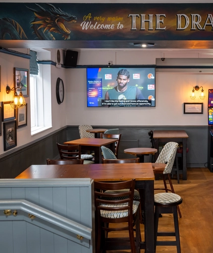 The interior restaurant and seating area with TV, bar, slot machine and signage  at the Dragon.