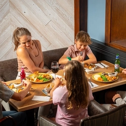 An image of a family enjoying a Sunday Roast and various drinks within the interior restaurant and seating area at a Hungry Horse venue.