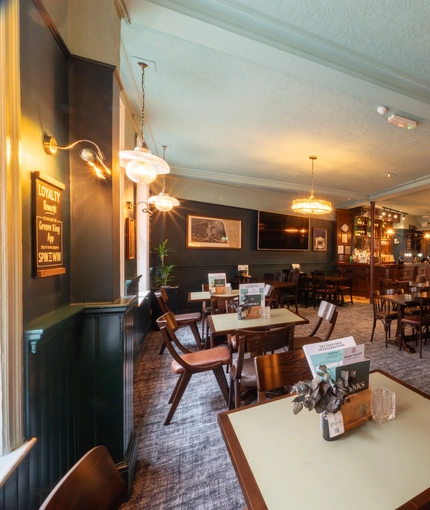 The interior restaurant seating area at the Lord Raglan in Holborn, with framed artwork and a TV on the wall.