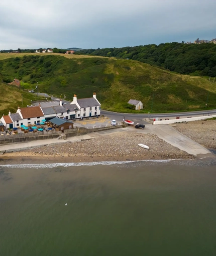Birdseye view of the venue, with scenic views of the waterside and hills surrounding 