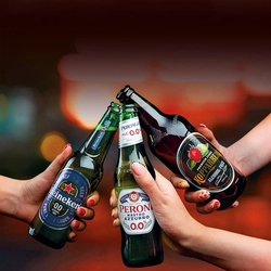 A bottle of 0% Kopparberg, 0% Peroni and 0% Heineken being cheersed.