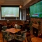 The interior restaurant seating area with tables, chairs, multiple TV screens and brick log burner fireplace at The Church View Inn.