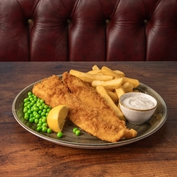 A plated serving of fish and chips on a table.