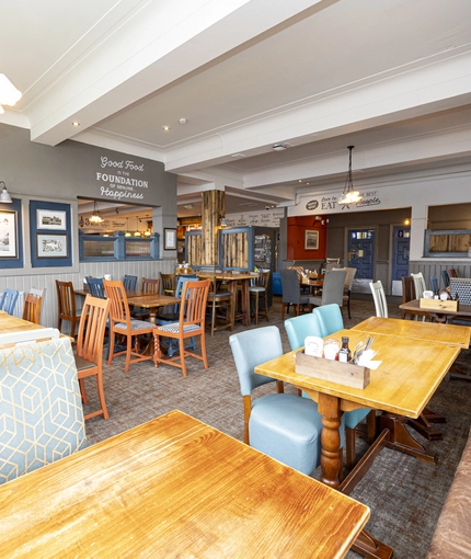 Interior dining area of a pub with a TV.