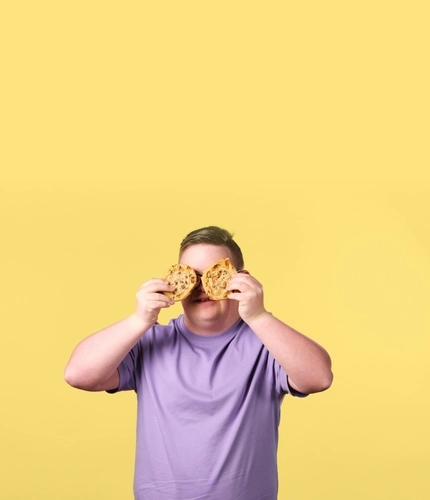 A boy holding cookies in front of his eyes