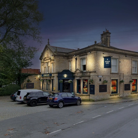The exterior facade and car park with venue signage at The Gerard Arms.