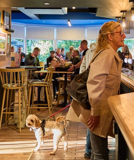 The bar and interior restaurant seating area of The Carousel, with people sitting at the tables and customers being served at the bar.